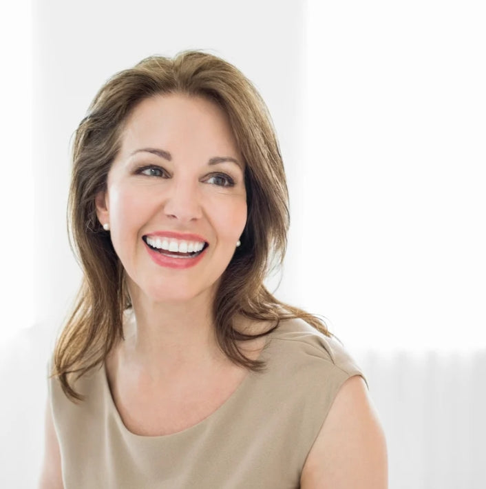 A smiling woman with healthy skin, showcasing the benefits of Vital Repair Oil in her daily beauty routine.