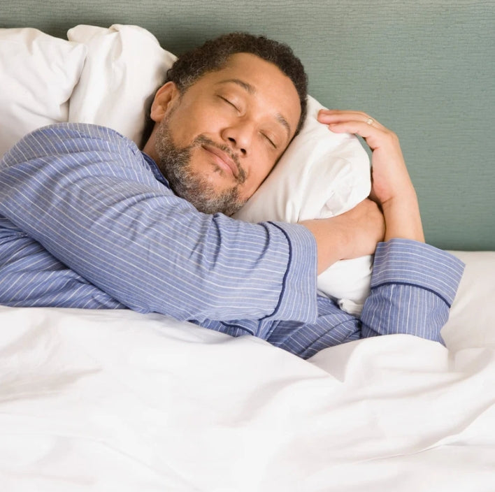 A man peacefully sleeping with a pillow, enjoying restful sleep with the Sleeping Harmony Helper.