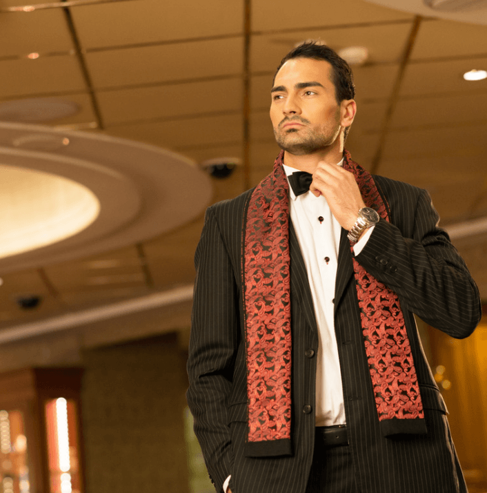 Model showcasing elegant attire with a red scarf, representing luxury fashion and style.