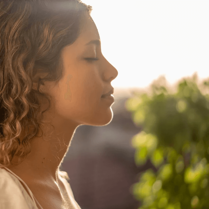 Young woman enjoying tranquility with Instant Repair Essence, showcasing a serene beauty routine.
