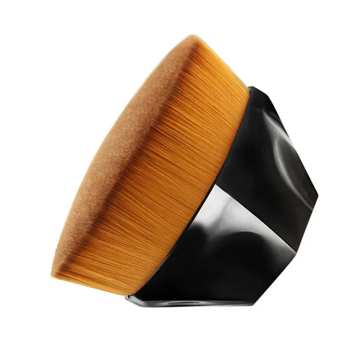 Close-up of a makeup brush with a unique hexagonal black base and soft orange bristles.