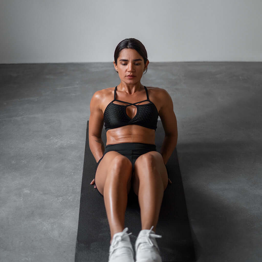 Woman exercising on a Zentheca ThryveMat Pro, showcasing comfort and support during her workout.
