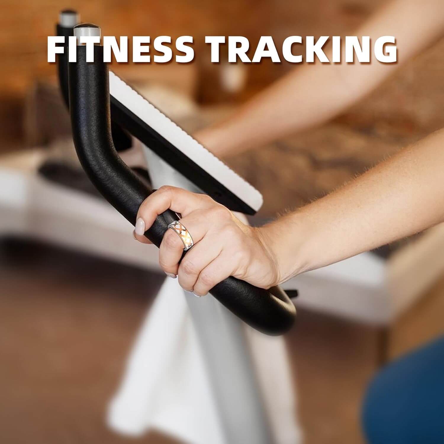 Hand holding exercise bike handlebars wearing Zentheca AuraRing for fitness and health tracking.
